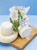 Various goat's cheeses on chopping board