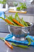 Fresh carrots and beans in a colander