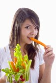 Girl biting into a fresh carrot