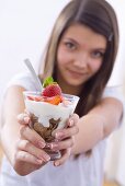 Girl holding yoghurt muesli with strawberries