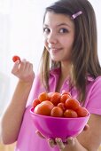 Girl holding a bowl of tomatoes