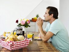 Mann sitzt am Frühstückstisch