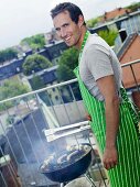 Mann grillt auf dem Balkon