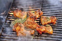 Chicken wings with rosemary on smoking barbecue