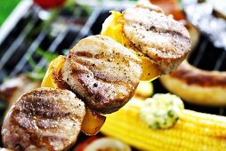 Grill meat kebab, corn on the cob with herb butter, sausage