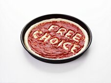 Pizza base with the words Free Choice in tomato sauce