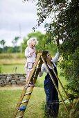 Mother and daughter picking cherries