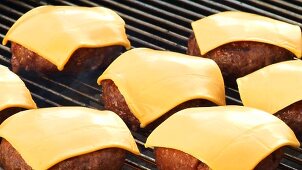 Burgers with cheese on a barbecue (for cheeseburgers)
