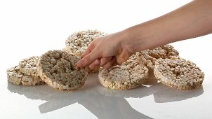 A pile of rice cakes and a hand taking one
