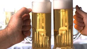 Hands clinking beer glasses