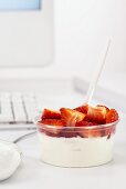 Bowl of quark with strawberries on office desk