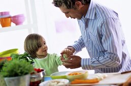 Father rolling up sleeves of son