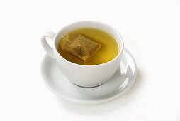 Peppermint tea with tea bag in cup and saucer