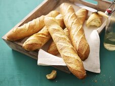 Several baguettes on wooden tray