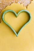 Heart-shaped cutter on biscuit dough