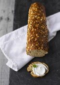 Multigrain baguette and baguette slice with cream cheese and basil leaf