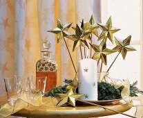 Adventsgesteck auf Goldschale, weiße Kerze und Goldsterne