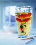 Maibowle-Glas mit fruchtigem Inhalt, Pfirsich mit Waldmeister