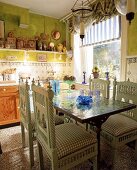 Apfelgrüne Küche mit Mosaiktisch und grünen, indischen Stühlen