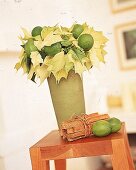 Grüngelber Weihnachtsstern mit Limonen in einer Vase