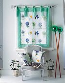 Transparenter Vorhang mit Blumenmotiv u. Sessel mit passenden Kissen