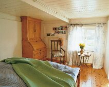 Holzverkleidete Decke, großer Raum, grüne Decke auf dem Bett