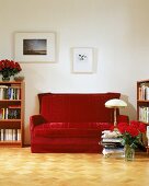 Ein antikes Polstersofa aus rotem Samt im Wohnzimmer