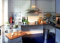 Küche mit Granitarbeitsplatte und großer Edelstahlesse.