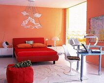 Schlafzimmer heiter und leger mit orangen Wänden u. rotem Bett