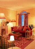 Wohnraum in warmen Farben gelb u.rot mit Polstersofa u. langen Vorhängen