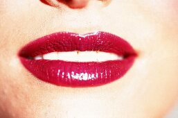 Frauenmund mit kräftig geschminkten Lippen in glänzendem Rot