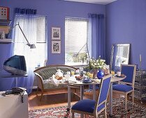 Arbeitszimmer in blau mit ovalem Schreibtisch, gedeckt zum Frühstück
