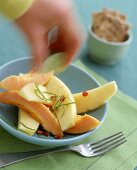 Exotischer Salat aus Papaya und Apfel in Scheiben geschnitten