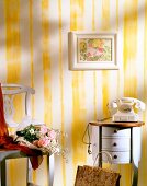 Room with yellow striped wall, telephone, chair and table