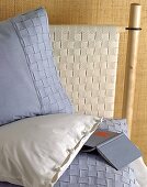 Blaue Bettwäsche mit einer geflochtenen Zierblende,Buch liegt auf Bett
