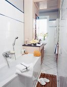 Badezimmer in weiß und beige, Wanne, Schrank mit integr. Waschplatz