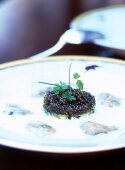 Close-up of oyster veloute with lemon and caviar on plate