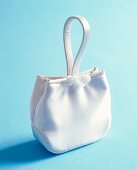 White bridal purse with chiffon roses on blue background