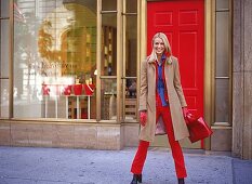Frau trägt roten Hosenanzug und braunen Kurzmantel, Tasche