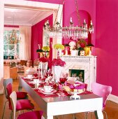 Dinning area decorated and set with pink furniture and large candlesticks