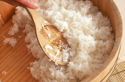 Reis mit Reisessig würzen und mit Holzspatel verrühren