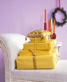 Ein Stapel gelb verpackter Geschenke mit glitzernden Schmuckbändern