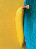 Künstliche Banane an blauem Tellerrand