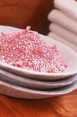 Aufeinander gesetellte Steinteller mit rosafarbenes Badesalz
