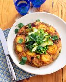 Potato tortilla with spring onion, peas, asparagus and chervil on plate