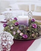 Purple layered lit candle decorated with hydrangea wreath and wire on plate