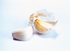 Close-up of garlic bulb and garlic cloves on white background