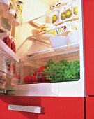 Geöffneter roter Kühlschrank mit 0°Grad-Fach und viel Inhalt