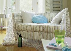 Helles Sofa mit leichtem Überwurf mit Streifenmuster, große Kissen