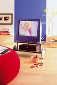 Blauer Fernseher + Videorecorder auf einem Rollwagen aus Glas + Chrom
